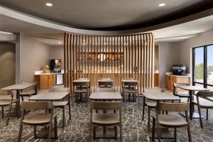 een restaurant met tafels en stoelen en een bar bij SpringHill Suites Fresno in Fresno