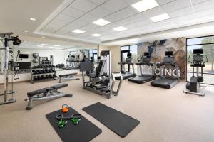 een fitnessruimte met verschillende loopbanden, gewichten en fitnessapparatuur bij SpringHill Suites Fresno in Fresno