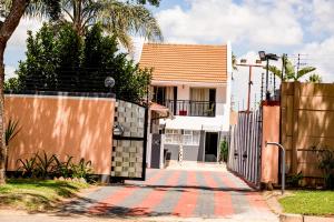 a house with a fence and a sidewalk at Lancaster Guest House in Boksburg