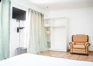 a living room with a chair and a television at Lancaster Guest House in Boksburg