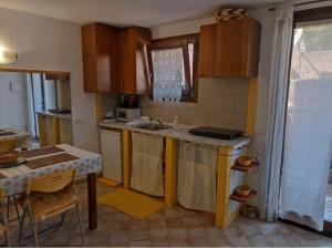 a kitchen with wooden cabinets and a table and a sink at La dolce dimora in Olbia