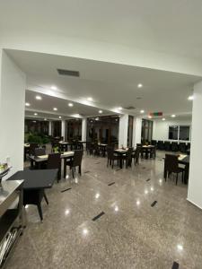 a dining room with tables and chairs in a building at Hotel Vienna in Herceg-Novi