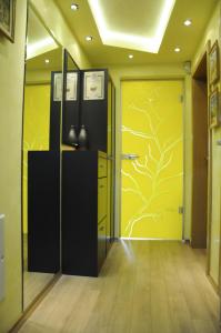 a hallway with a yellow wall with a tree painted on it at DERELLI Deluxe and DERELLI Adorable apartments in Sofia