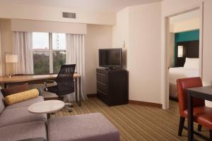 a hotel room with a couch and a tv and a bed at Residence Inn Orlando Convention Center in Orlando
