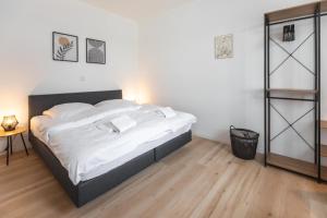 - une chambre avec un grand lit et des draps blancs dans l'établissement Koje Sieben I Apartment im Zentrum mit Meerblick, à Bremerhaven