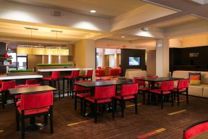 a restaurant with tables and chairs and a bar at Courtyard Kansas City East/Blue Springs in Blue Springs