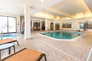 a pool in a hotel with a table and chairs at Courtyard Kansas City East/Blue Springs in Blue Springs