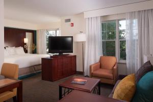 Residence Inn Fort Myers Sanibel في Truckland: غرفة فندقية بسرير وتلفزيون بشاشة مسطحة