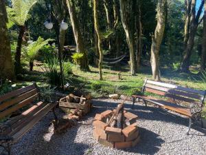 a park with two benches and a fire pit at Lala Haus Gramado in Gramado