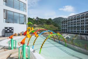 a pool with a water slide in a building at Sheraton Maoming Hot Spring Resort in Maoming