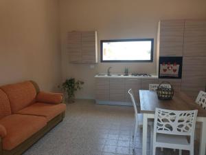sala de estar con sofá, mesa y cocina en Mediresidence Maeggio, en Contrada Maeggio