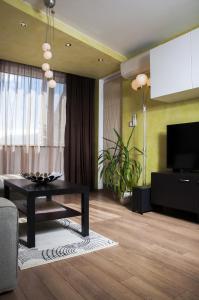 uma sala de estar com uma mesa e uma televisão de ecrã plano em DERELLI Deluxe and DERELLI Adorable apartments em Sófia