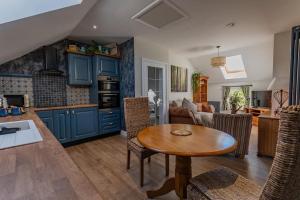 cocina con armarios azules y mesa de madera en Luxury retreat in Lincolnshire with hot tub en Cranwell