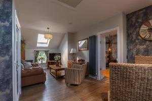 a living room with a couch and a clock on the wall at Luxury retreat in Lincolnshire with hot tub in Cranwell