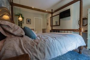 a bedroom with a large bed with a wooden frame at Luxury retreat in Lincolnshire with hot tub in Cranwell