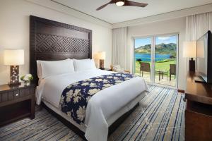 um quarto com uma cama grande e uma janela grande em Marriott's Kauai Lagoons - Kalanipu'u em Lihue