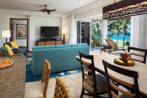 sala de estar con sofá azul y sillas en Marriott's Kauai Lagoons - Kalanipu'u, en Lihue
