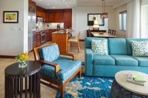 a living room with a blue couch and a kitchen at Marriott's Kauai Lagoons - Kalanipu'u in Lihue