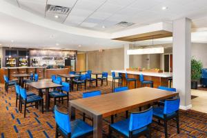 uma sala de jantar com mesas e cadeiras azuis em Courtyard Phoenix North / Happy Valley em Phoenix