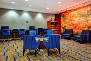 鳳凰城的住宿－鳳凰城北/歡樂谷萬怡酒店，一间会议室,配有蓝色椅子和绘画作品