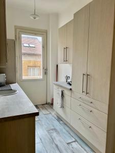a kitchen with wooden cabinets and a sink and a window at BEM by Small Home Budapest in Budapest