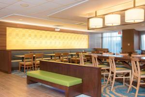 Fairfield Inn & Suites by Marriott Tampa Westshore/Airport في تامبا: غرفة طعام مع طاولات وكراسي خشبية