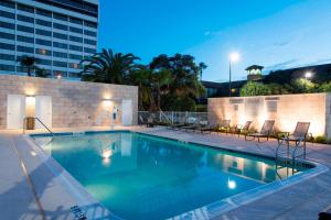 Fairfield Inn & Suites by Marriott Tampa Westshore/Airport في تامبا: مسبح وكراسي ومبنى