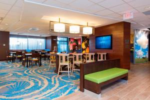 a restaurant with tables and chairs and a green bench at Fairfield Inn & Suites by Marriott Tampa Westshore/Airport in Tampa