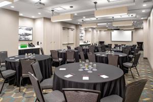 a conference room with tables and chairs and a screen at Residence Inn by Marriott Toronto Mississauga West in Mississauga