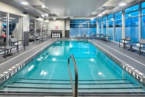 - une piscine d'eau bleue dans un bâtiment dans l'établissement Residence Inn by Marriott Toronto Mississauga West, à Mississauga