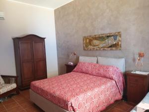 1 dormitorio con 1 cama con colcha roja en Mediresidence Maeggio, en Contrada Maeggio