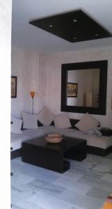 sala de estar con sofá y espejo grande en Ático Aretusa, en Zahara de los Atunes
