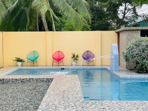 two chairs with umbrellas sitting next to a swimming pool at Hotel El Chaman in Uvita