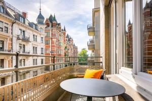 a balcony with a table and a view of buildings at Neues Schloss Privat Hotel Zurich, Autograph Collection in Zurich