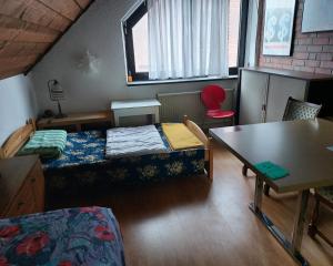 Zimmer mit 2 Betten und einem Tisch in der Unterkunft Zimmer im Landhaus in Erkelenz