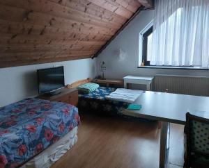 1 dormitorio con 2 camas, escritorio y TV en Zimmer im Landhaus, en Erkelenz