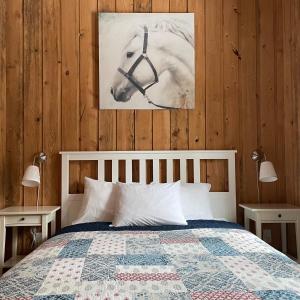 a bedroom with a bed and a picture of a horse at Chalets du Domaine Yamaska in Bromont