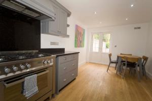 a kitchen with a stove and a table in it at Wolviston Cottage in Wolviston