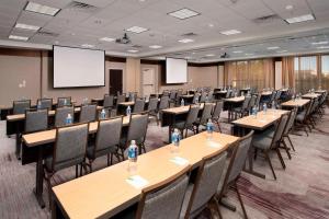 a conference room with tables and chairs and a projection screen at Courtyard by Marriott Tyler in Tyler