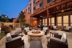 a patio with chairs and a fire pit in front of a building at Courtyard by Marriott Tyler in Tyler