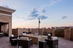 Courtyard by Marriott San Angelo في سان أنجيلو: فناء مع حفرة نار على سقف مبنى