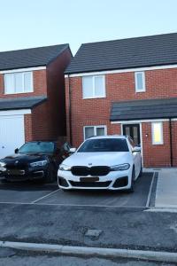 two cars parked in a parking lot in front of houses at 3 Bedroom Full Property in Cramlington