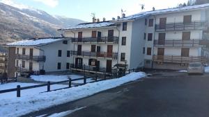 un gran edificio blanco con nieve en el suelo en Appartamento di montagna, en Morgex