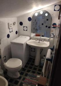y baño con aseo, lavabo y espejo. en Appartamento di montagna, en Morgex