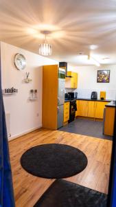 cocina con armarios amarillos y alfombra negra en Lovely 1-Bed Apartment in Hackney London, en Londres