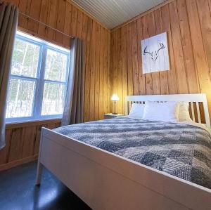 a bedroom with a bed in a wooden wall at Chalets du Domaine Yamaska in Bromont