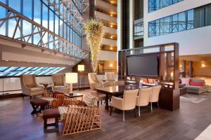 a lobby with a table and chairs and a television at Salt Lake City Marriott University Park in Salt Lake City