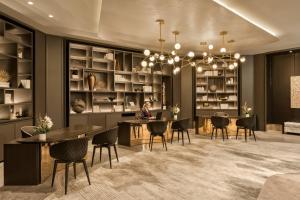 a rendering of a dining room with a woman sitting at a table at JW Marriott Parq Vancouver in Vancouver