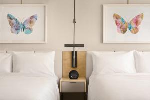 two beds in a bedroom with two butterflies on the wall at JW Marriott Parq Vancouver in Vancouver