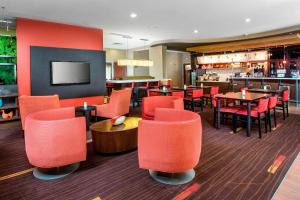 a restaurant with red chairs and tables and a bar at Courtyard by Marriott Peoria in Peoria